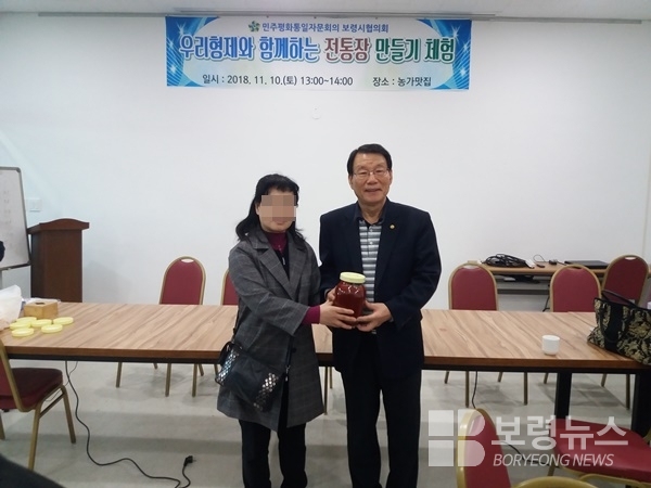 북한 이탈 주민과 함께한 전통주(고추장) 담그기 실습을 통해 만들어진 고추장을 김정원회장(왼쪽)이 이탈 주민에게 전달하고 있다.